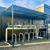 black steel bike shelter with two tier rack installed outside a commercial property