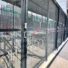 black steel bike shelter with two tier rack installed with mesh sliding gates