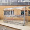 metal bike shelter with two tier racks outside brick building