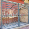 metal bike shelter with mesh sliding fence outside of a commercial building