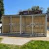 wooden bike shelter with swing mesh gate outside