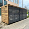 wooden cycle shelter outside of a commercial building with sliding mesh gates