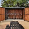 wooden cycle shelter with two tier cycle racks installed and swing doors