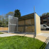 wooden bike shelter with swing mesh gate outside