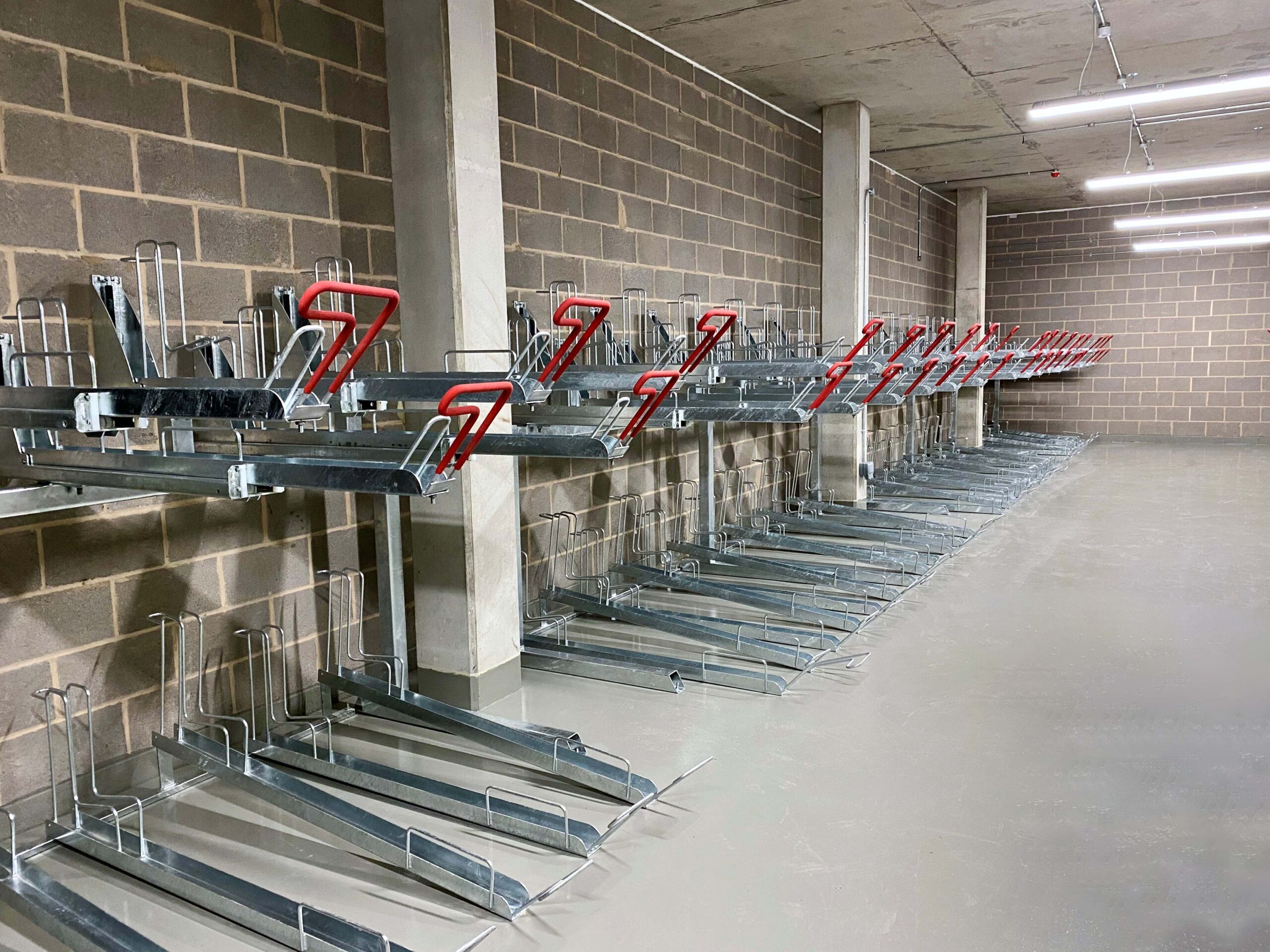 gas assisted two tier bike rack with red galvanised handles in commercial building
