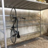 metal bike shelter with vertical storage with bike hanging up securely