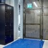 Perforated mesh fencing swing gate installed in an underground cycle storage facility next to a 3 tier bike locker