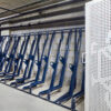 semi vertical bike racks in RAL colour blue behind a perforated mesh gate
