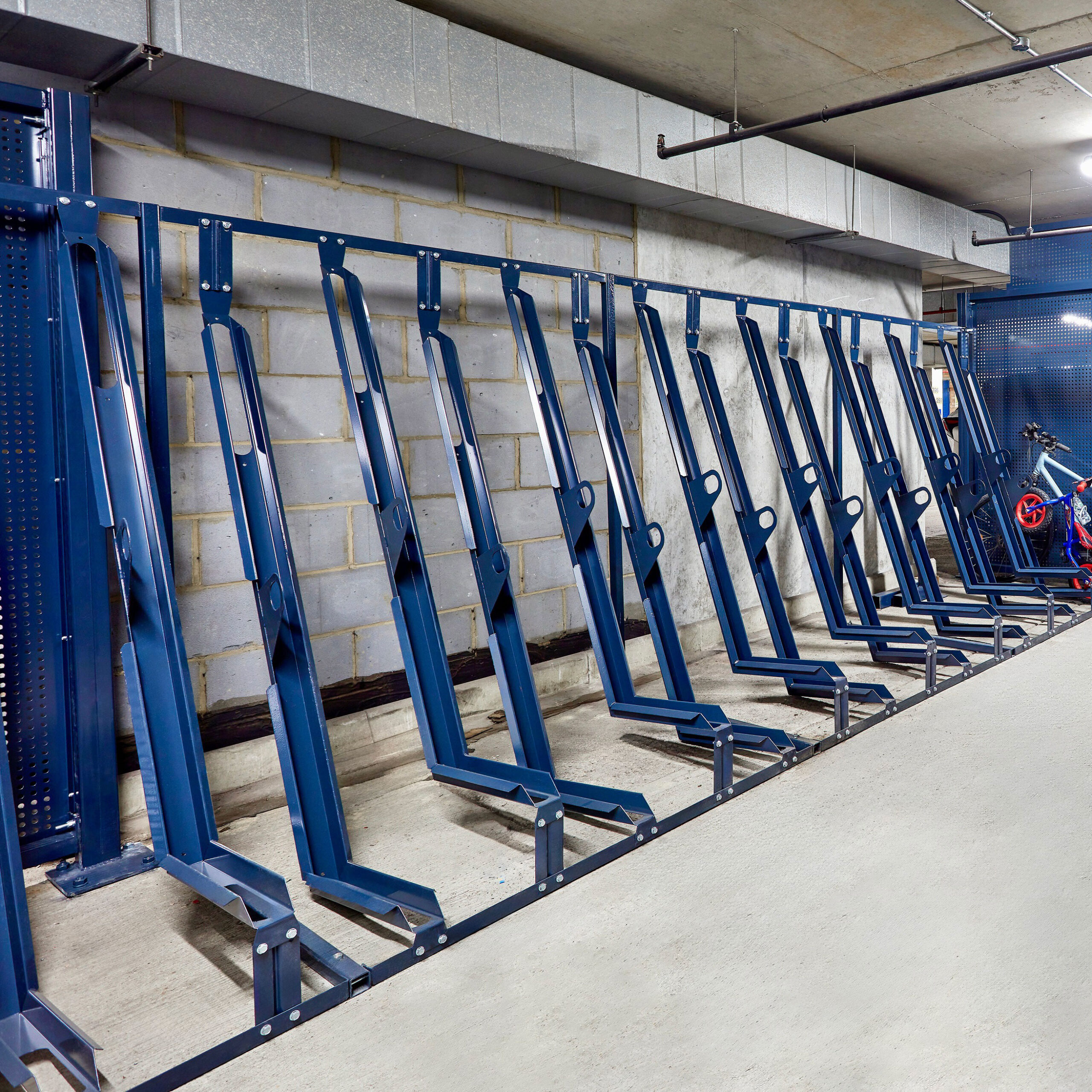 close up of blue semi vertical bike racks in underground bike storage