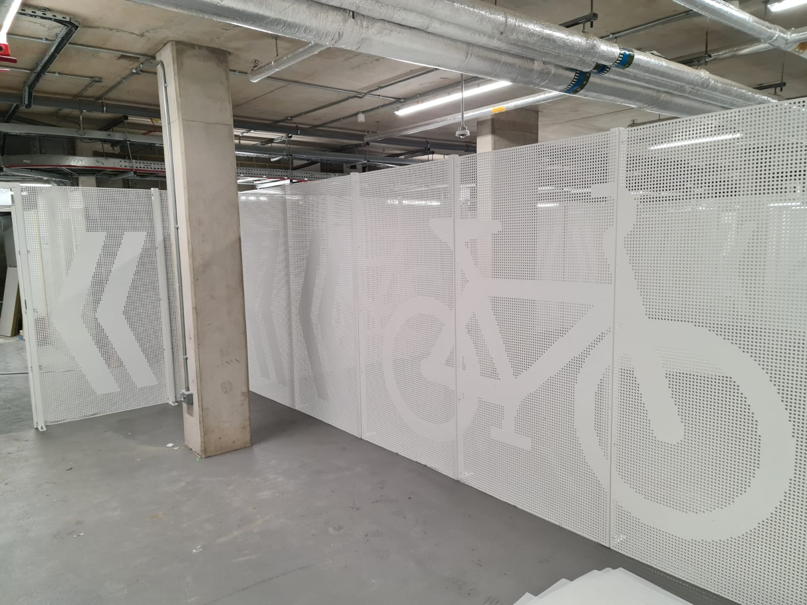 White perforated security mesh fencing with logo of bike