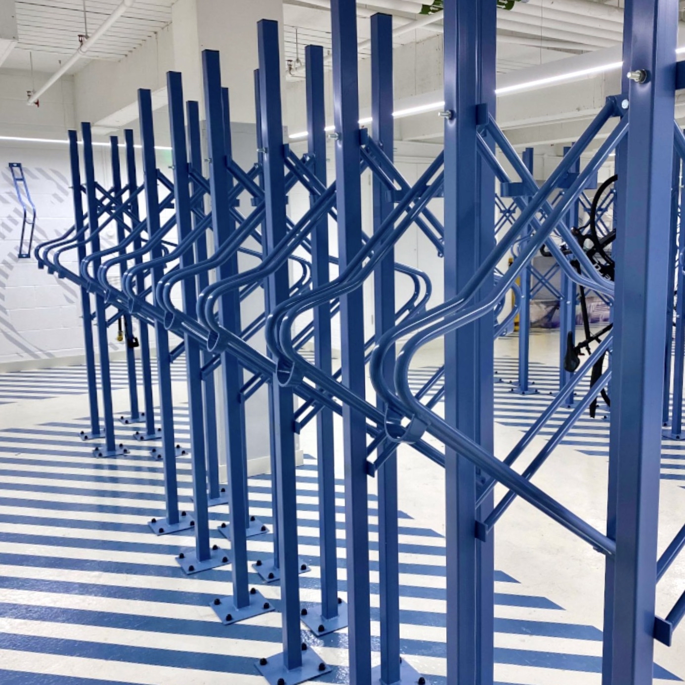 indoor blue premium solo vertical bike rack in a commercial building