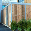 wooden cycle shelter with green shrubbery in-front and mesh swing door