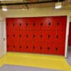 Islington Locker installed in a cycle storage end of trip facility, with red doors and black locks, on top of a yellow floor.