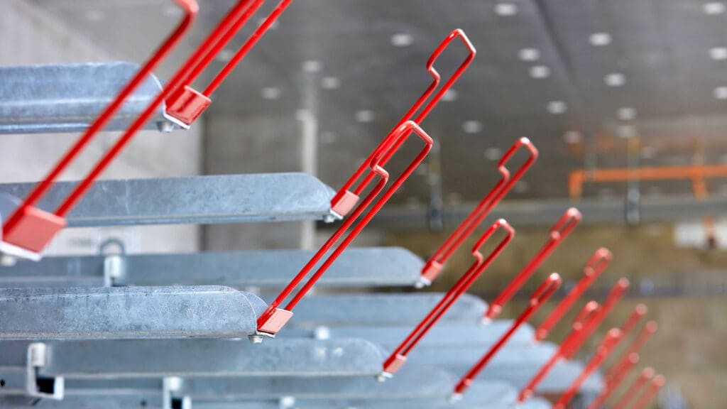 Two Tier Bike Rack with red RAL handles installed in an underground cycle storage area