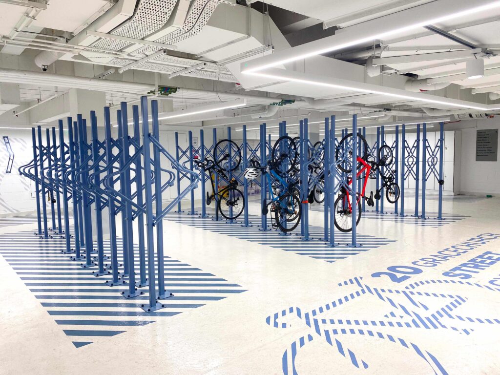 British-made vertical bike racks coloured Sapphire blue in a luxury internal bike parking area